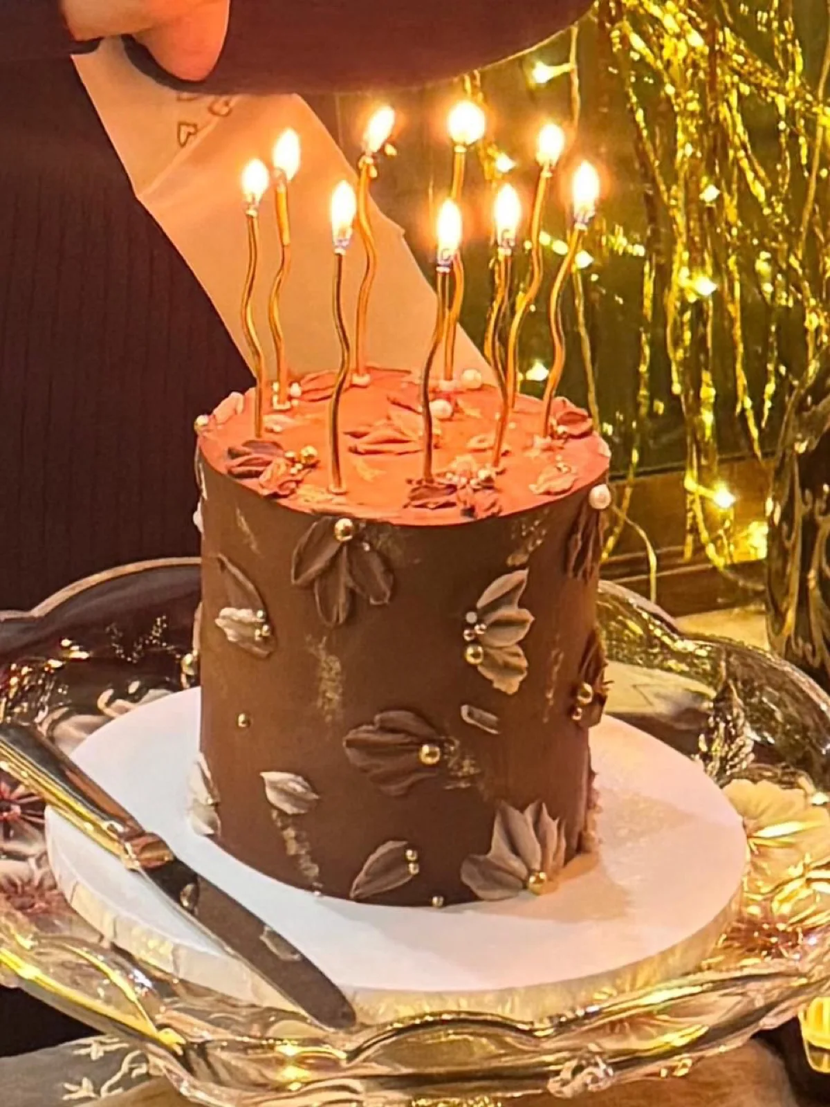 Chocolate buttercream cake with piped petals and tall candles