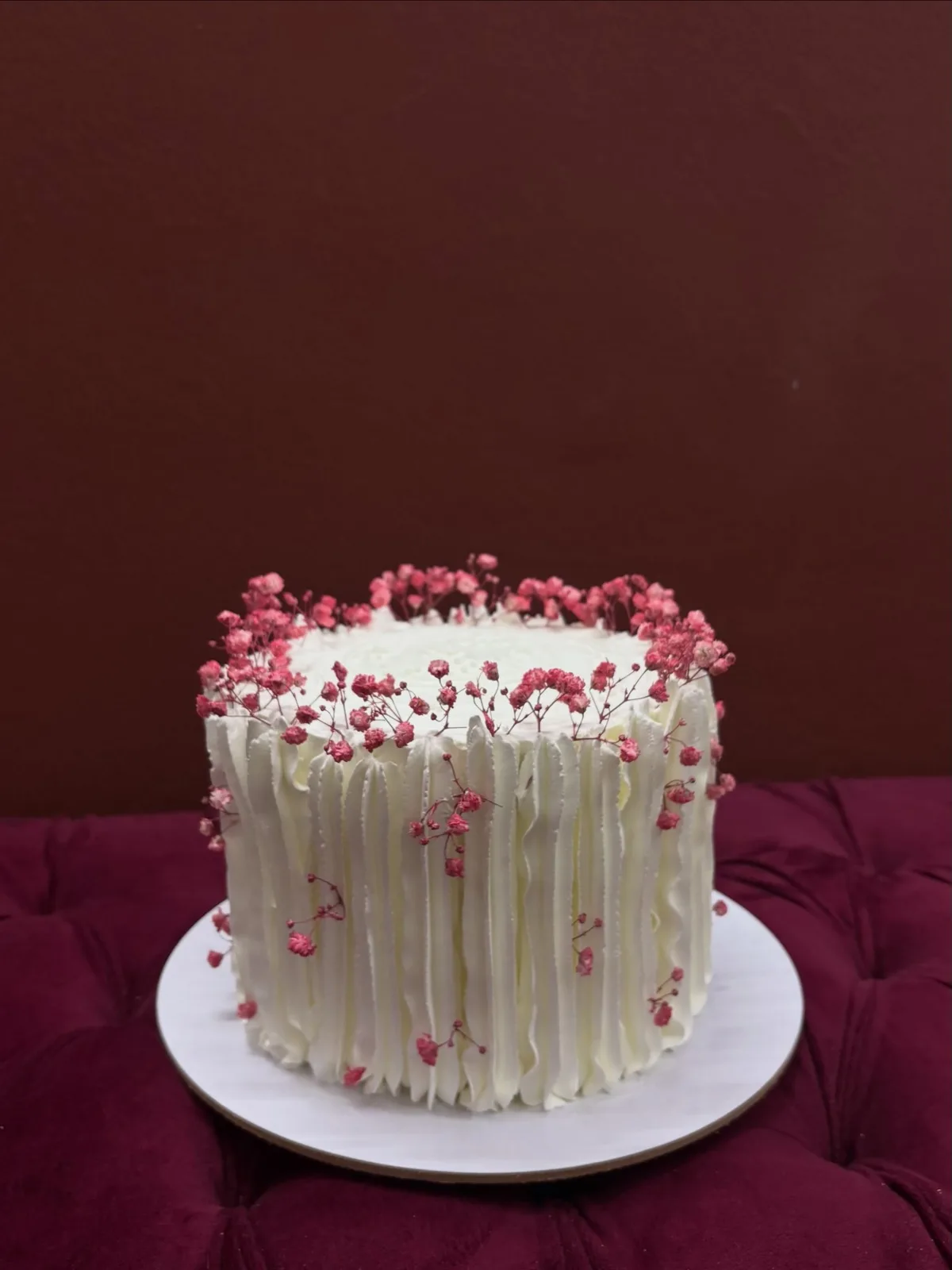 White chocolate drip cake with pink baby's breath
