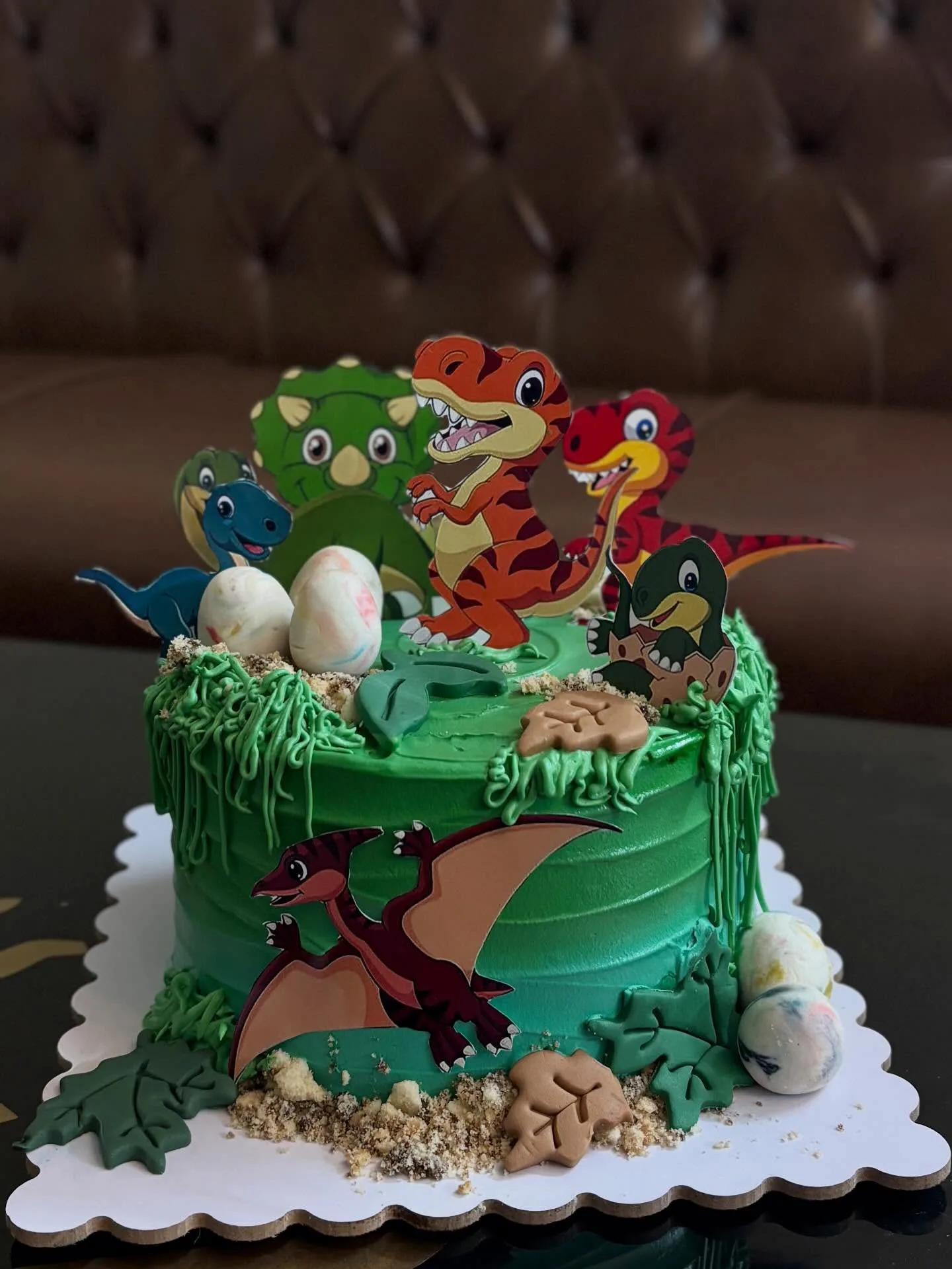 Dinosaur jungle cake with green buttercream, fondant eggs and dinosaur toppers