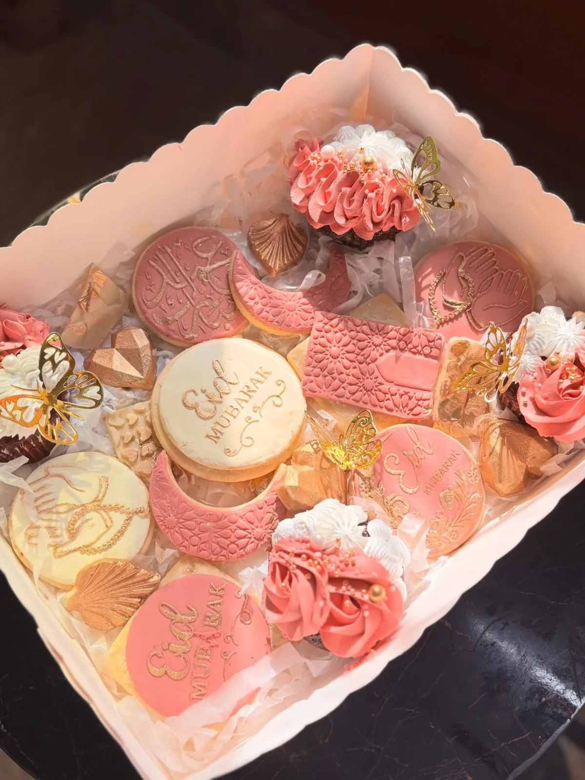 Eid dessert box of decorated cookies and mini cupcakes in pink and gold