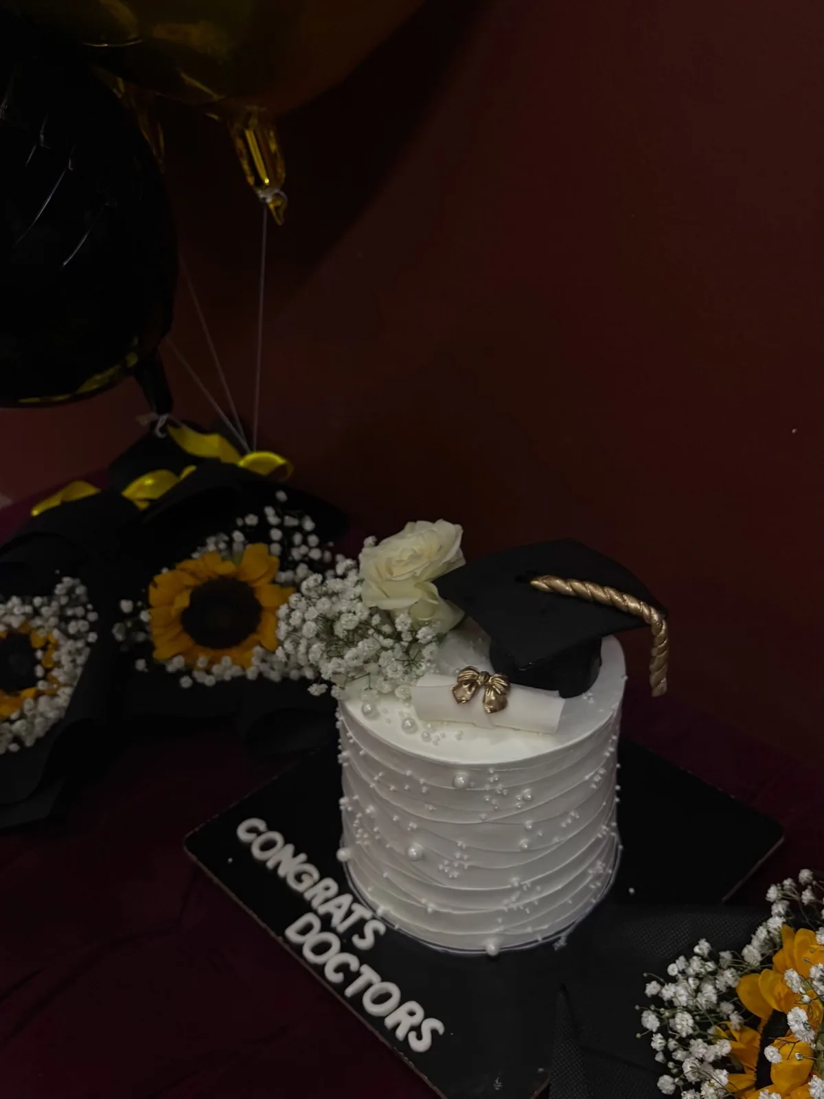 Graduation cake with sunflowers and a fondant graduation cap