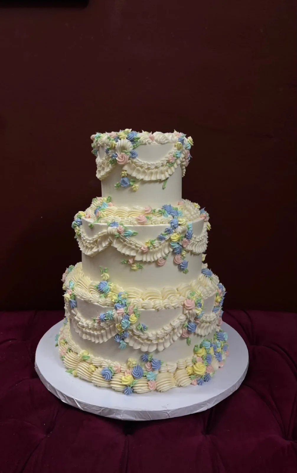 Three-tier vintage buttercream cake with pastel piped swags and flowers