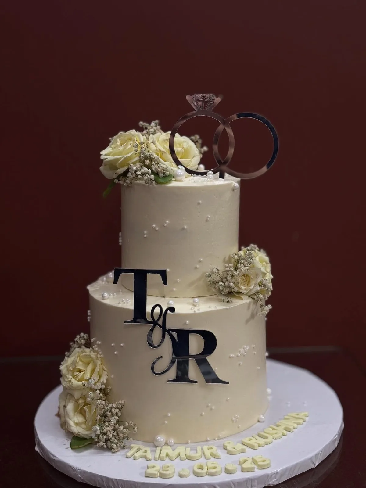 Two-tier engagement cake with monogram and ring topper